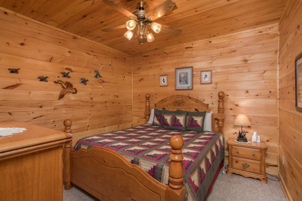 Bedroom with a queen bed, night stand, and lamp at Friends in High Places, a 4-bedroom cabin rental located in Pigeon Forge