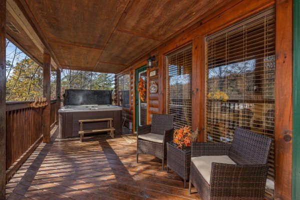Covered deck with a hot tub and seating at Close at Heart, a 1 bedroom cabin rental located in Pigeon Forge