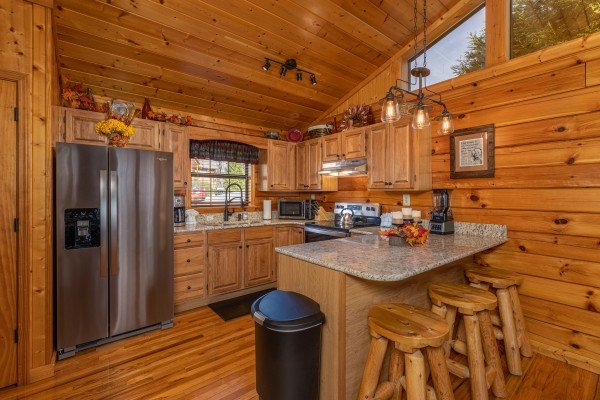 Breakfast bar for three and kitchen with stainless appliances at Close at Heart, a 1 bedroom cabin rental located in Pigeon Forge