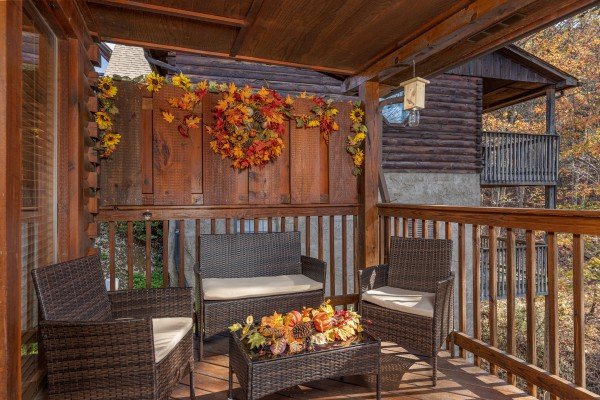 Padded seating on a covered deck at Close at Heart, a 1 bedroom cabin rental located in Pigeon Forge