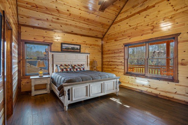 King bedroom with bedside table and lamp at Mountain Joy, an 8 bedroom cabin rental located in Pigeon Forge