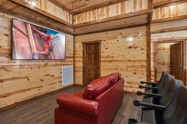 Theater room with couch and theater seating at Mountain Joy, an 8 bedroom cabin rental located in Pigeon Forge