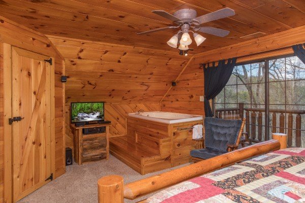 Bedroom with private deck access, in room jacuzzi, and TV at Hidden Pleasure, a 1-bedroom cabin rental located in Gatlinburg
