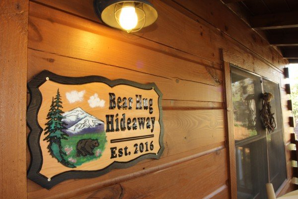 Custom welcome sign at Bear Hug Hideaway, a 1-bedroom cabin rental located in Pigeon Forge