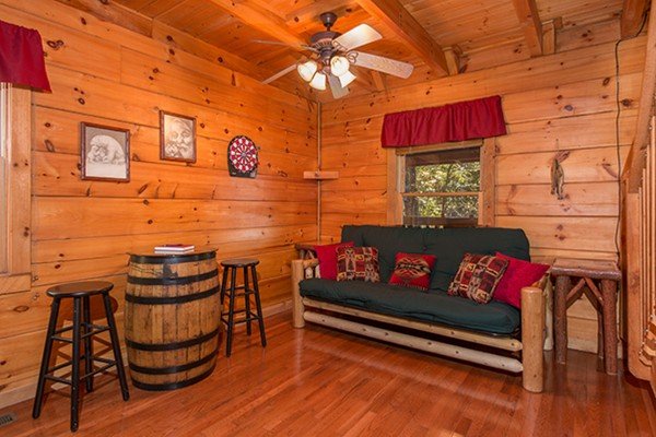 Futon and table at Bear Hug Hideaway, a 1-bedroom cabin rental located in Pigeon Forge