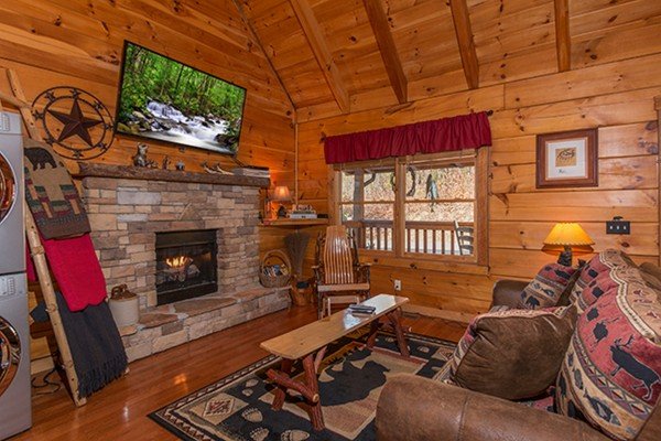 Living room with fireplace and TV at Bear Hug Hideaway, a 1-bedroom cabin rental located in Pigeon Forge
