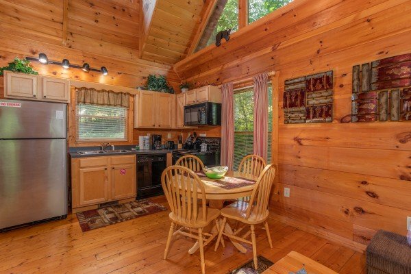 Dining space for four and kitchen at Swept Away in the Smokies, a 1 bedroom cabin rental located in Pigeon Forge