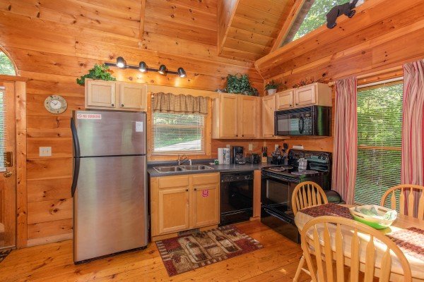 Kitchen and dining space on the main floor at Swept Away in the Smokies, a 1 bedroom cabin rental located in Pigeon Forge