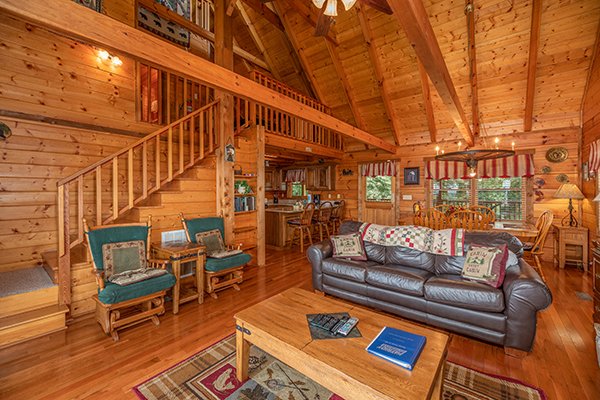 Two gliders and a sofa in the open living room at Eagles View Lodge, a 3 bedroom cabin rental located in Gatlinburg