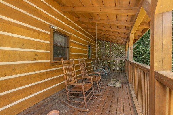 Rocking chairs and a swing on a deck at Eagles View Lodge, a 3 bedroom cabin rental located in Gatlinburg