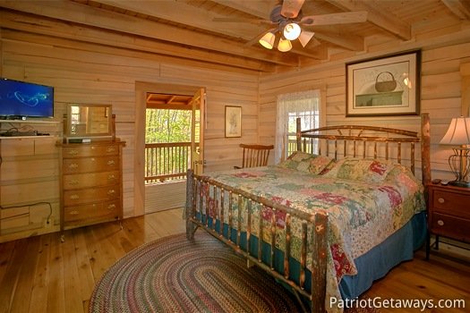Queen sized bed in main level bedroom at On Angels Wings, a 5 bedroom cabin rental located in Gatlinburg
