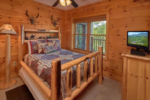 Queen bedroom with dresser and TV at Wagon Wheel Cabin, a 3 bedroom cabin rental located in Pigeon Forge