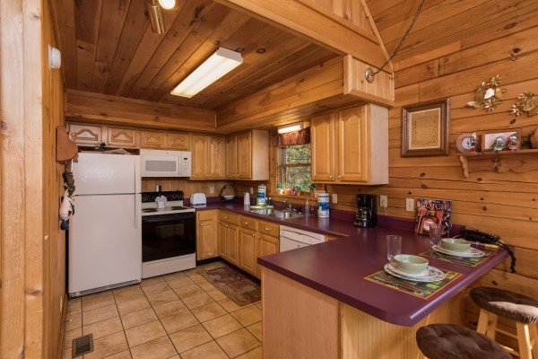 Kitchen with breakfast bar and white appliances at R & R Hideaway, a 1 bedroom cabin rental located in Pigeon Forge