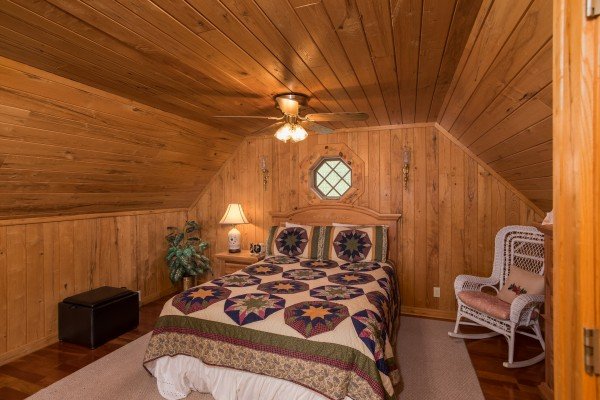 Loft bedroom with a bed, night stand, lamp, and chair at R & R Hideaway, a 1 bedroom cabin rental located in Pigeon Forge