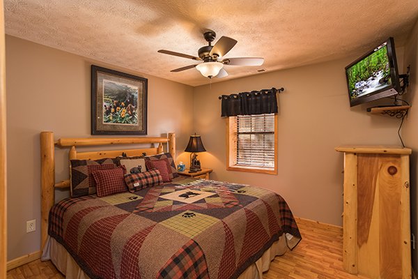 King bedroom with a dresser and TV at The Bear's House, a 4 bedroom cabin rental in Pigeon Forge