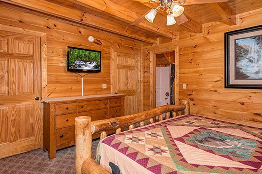 Bedroom with a dresser, TV, and en suite at Lazy Bear Lodge, a 2 bedroom cabin rental located in Pigeon Forge