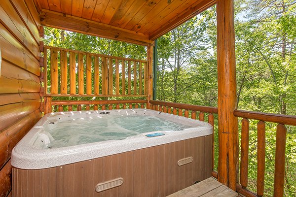 Hot tub with privacy fence and wooded views at Bearfoot Paradise, a 3-bedroom cabin rental located in Pigeon Forge
