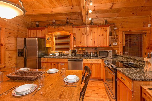 Dining table in the kitchen with stainless steel appliances at Bearfoot Paradise, a 3-bedroom cabin rental located in Pigeon Forge