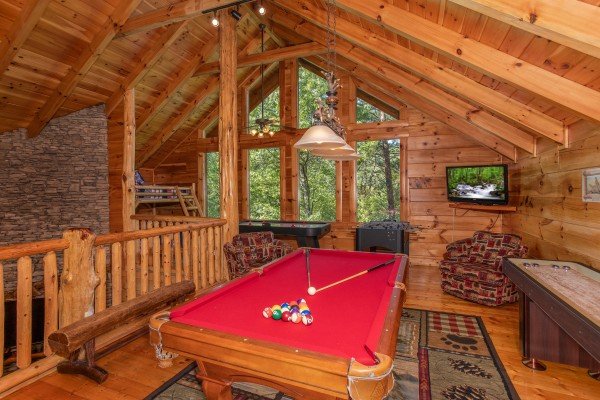Red felted pool table in the game loft at Bearfoot Paradise, a 3-bedroom cabin rental located in Pigeon Forge