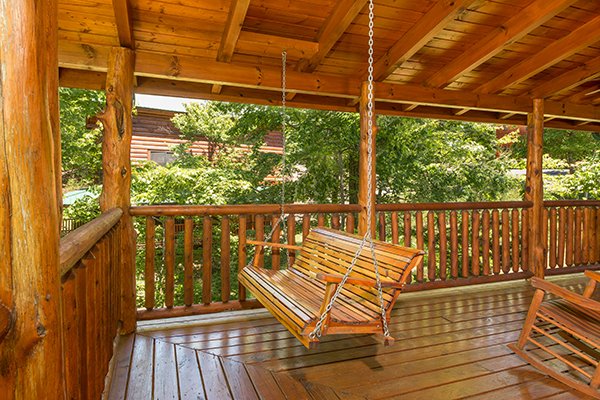 Swing on a covered porch at Bearfoot Paradise, a 3-bedroom cabin rental located in Pigeon Forge