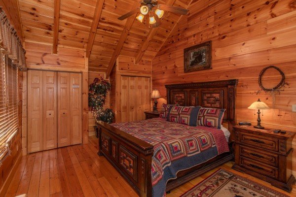 Bedroom with a king-sized wooden bed at Bearfoot Paradise, a 3-bedroom cabin rental located in Pigeon Forge