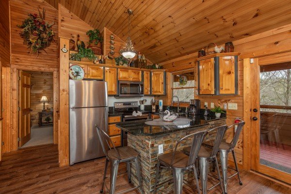 Dining at the breakfast bar in the kitchen at Fowl Play, a 1 bedroom cabin rental located in Pigeon Forge
