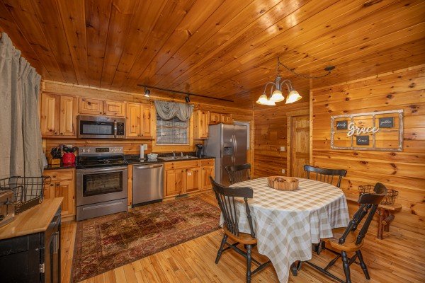 Kitchen with stainless appliances and a dining table for four at Whispering Grace, a 2 bedroom cabin rental located in Gatlinburg