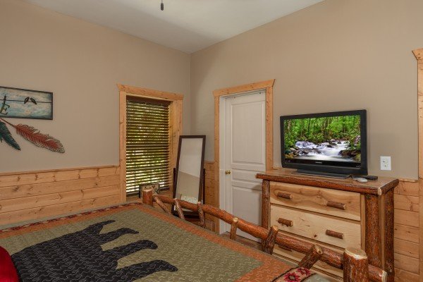 Dresser, mirror, and tv in a bedroom at Hawk’s Heart Lodge, a 3 bedroom cabin rental located in Pigeon Forge
