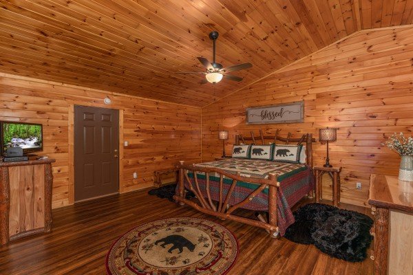 Bedroom with a log bed, dressers, and a TV at Hawk’s Heart Lodge, a 3 bedroom cabin rental located in Pigeon Forge