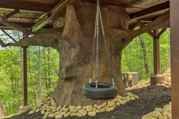 A tire swing mounted to the underside of the cabin at Gatlinburg Treehouse, a 1-bedroom cabin rental located in Gatlinburg