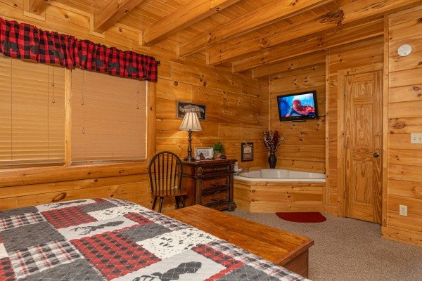Jacuzzi, TV, and dresser in a bedroom at Absolutely Wonderful, a 2 bedroom cabin rental located in Pigeon Forge