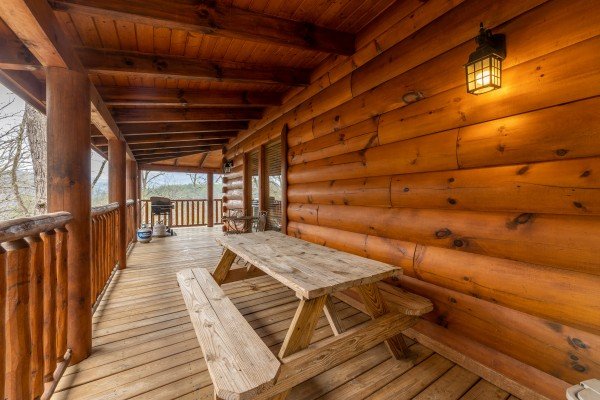 Picnic table on the covered deck at Absolutely Wonderful, a 2 bedroom cabin rental located in Pigeon Forge
