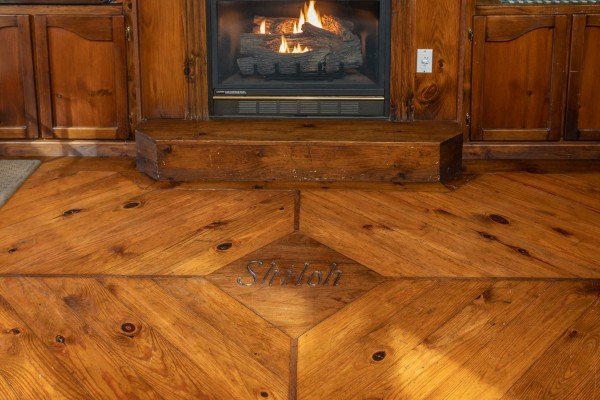 Custom flooring inlay in front of the living room fireplace at Shiloh, a 3 bedroom cabin rental located in Gatlinburg