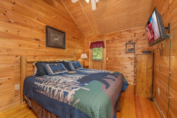 Bedroom with a king bed, night stand, lamp, dresser, and TV at Moonlight in the Boondocks, a 2 bedroom cabin rental located in Gatlinburg