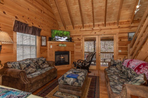 Living room with fireplace, TV, and two sofas at My Smoky Mountain Hideaway, a 3 bedroom cabin rental located in Pigeon Forge