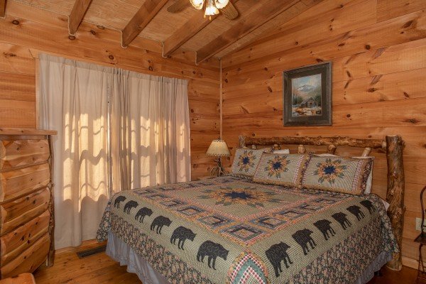 King bed and log dresser in a bedroom at My Smoky Mountain Hideaway, a 3 bedroom cabin rental located in Pigeon Forge