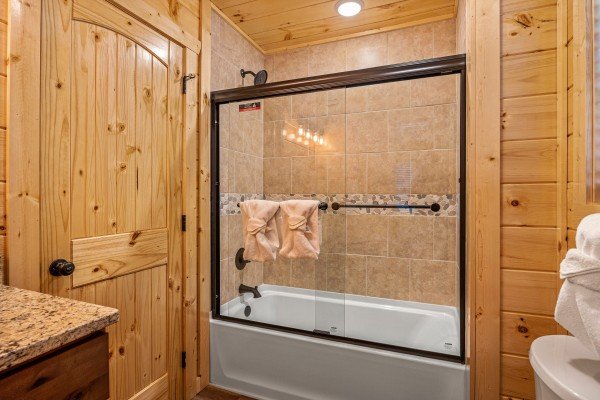 Bathroom with bathtub and shower at Swimmin' Hole In 1, a 2 bedroom cabin rental located in Gatlinburg