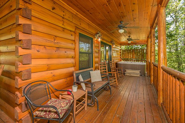 Back deck with a chair, bench, and rockers at Bearfoot Paradise, a 3-bedroom cabin rental located in Pigeon Forge