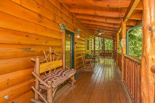 Bench and rockers on the covered deck at Bearfoot Paradise, a 3-bedroom cabin rental located in Pigeon Forge