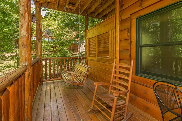 Deck with a porch swing and rocking chair at Bearfoot Paradise, a 3-bedroom cabin rental located in Pigeon Forge