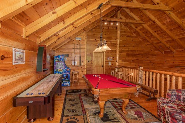 Shuffleboard and pool tables in the game loft at Bearfoot Paradise, a 3-bedroom cabin rental located in Pigeon Forge