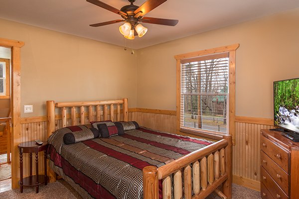 Bedroom with a queen bed, dresser, and TV at Lucky Logs, a 3 bedroom cabin rental located in Gatlinburg