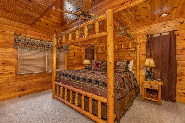 Bedroom with a four post log bed at Rainbow's End, a 4 bedroom cabin rental located in Pigeon Forge