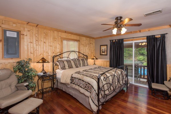 Bedroom with a queen bed and deck access at Breezy Mountain Lodge, an 11-bedroom cabin rental located in Pigeon Forge