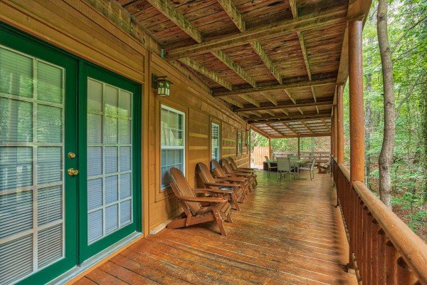 Adirondack chairs on a covered deck at Breezy Mountain Lodge, an 11-bedroom cabin rental located in Pigeon Forge