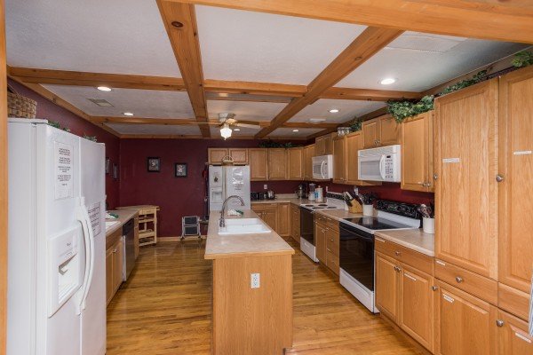 A kitchen with 2 fridges, 2 stoves/ovens, 2 microwaves, and a dishwasher at Breezy Mountain Lodge, an 11-bedroom cabin rental located in Pigeon Forge