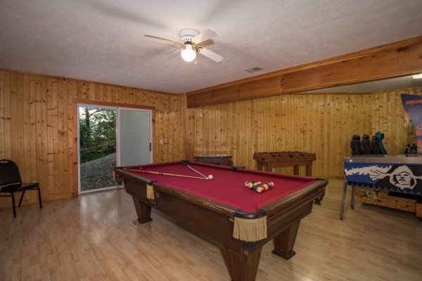 Red felted pool table in the game room at Breezy Mountain Lodge, an 11-bedroom cabin rental located in Pigeon Forge