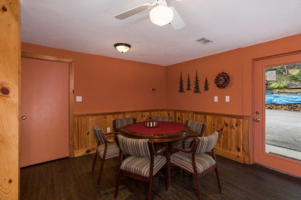 Poker table with cushioned seating at Breezy Mountain Lodge, an 11-bedroom cabin rental located in Pigeon Forge