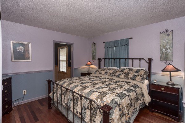 A purple room with a king-sized bed at Breezy Mountain Lodge, an 11-bedroom cabin rental located in Pigeon Forge