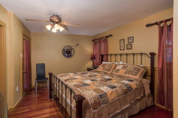 Tan bedroom with a king-sized bed at Breezy Mountain Lodge, an 11-bedroom cabin rental located in Pigeon Forge